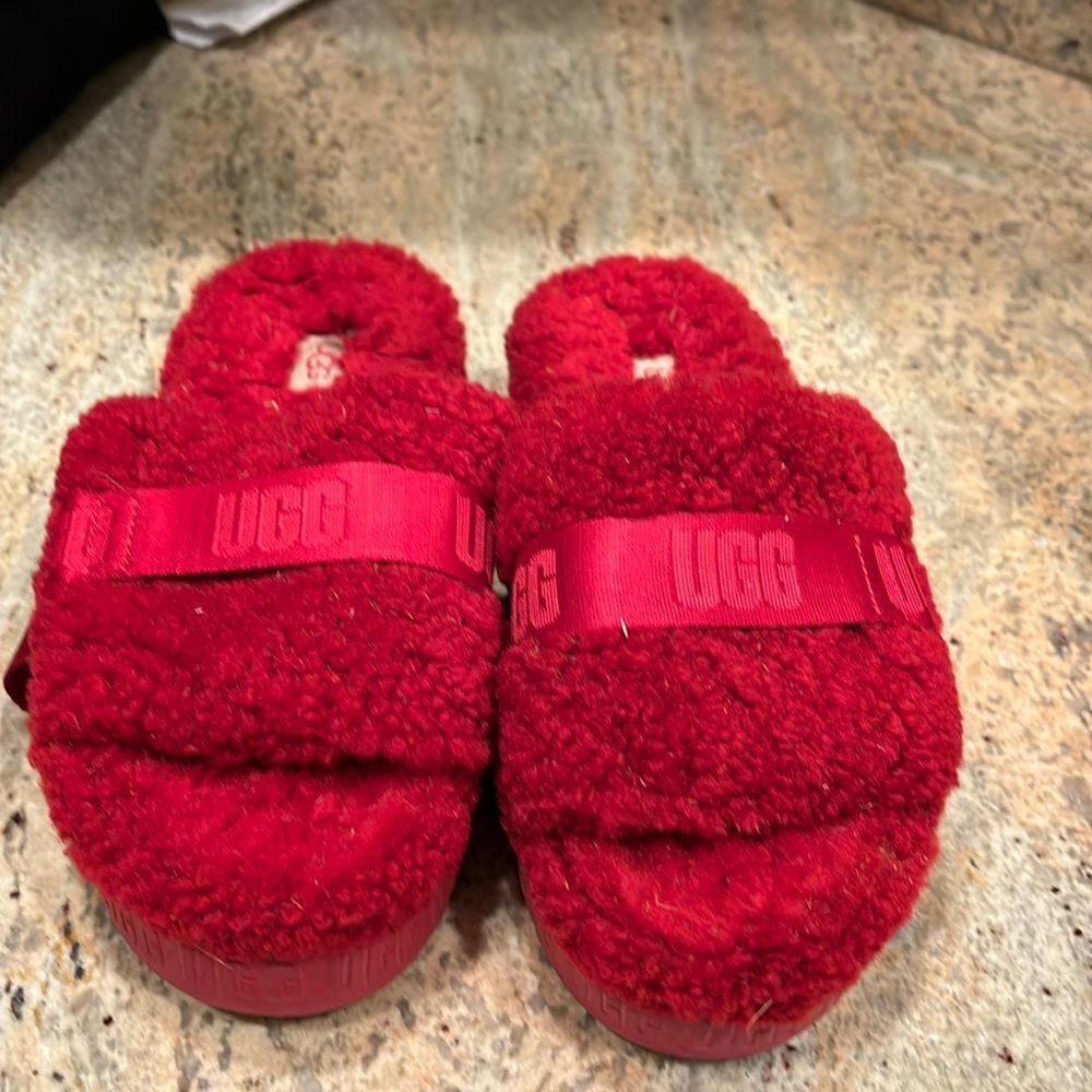 Ugg fuzzy woman's red slippers. They have some dirt and grass on them